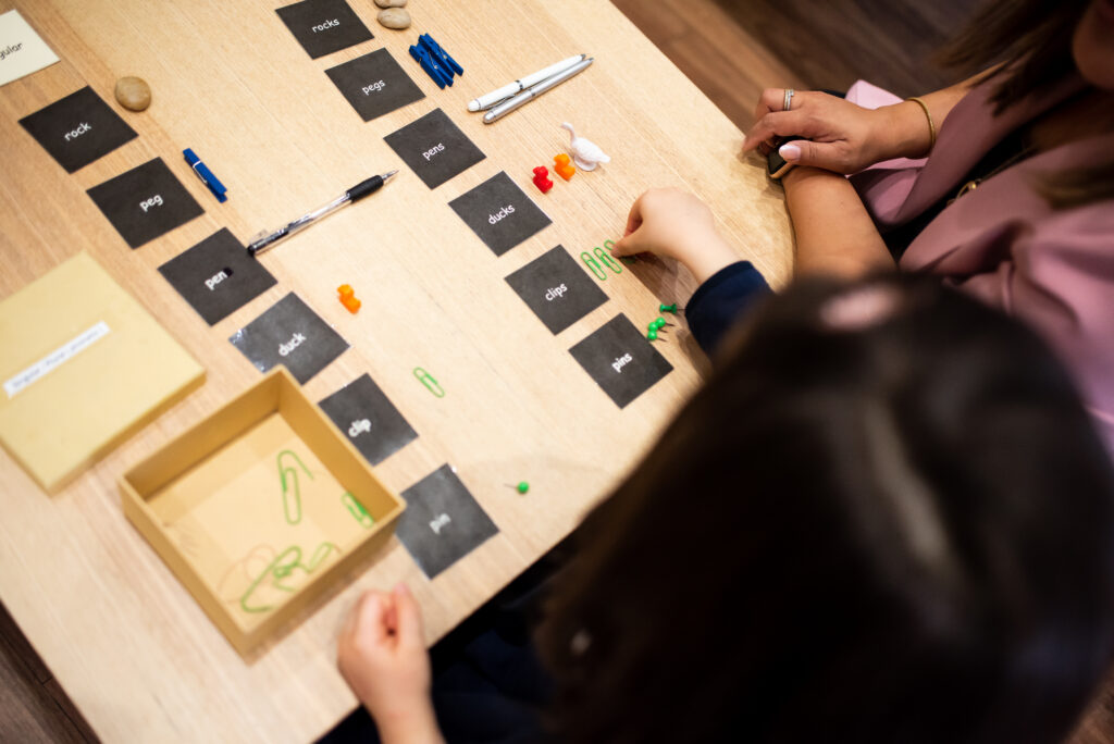 Child and adult playing word card game.