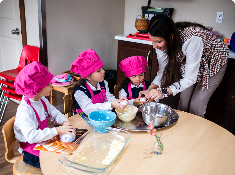 Children cooking with teacher in classroom kitchen.