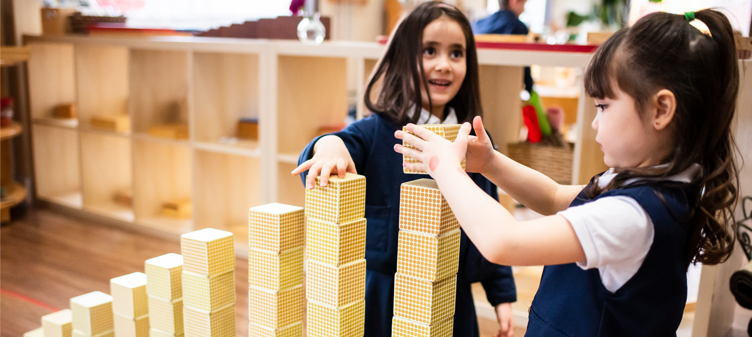 Children building with yellow block towers.