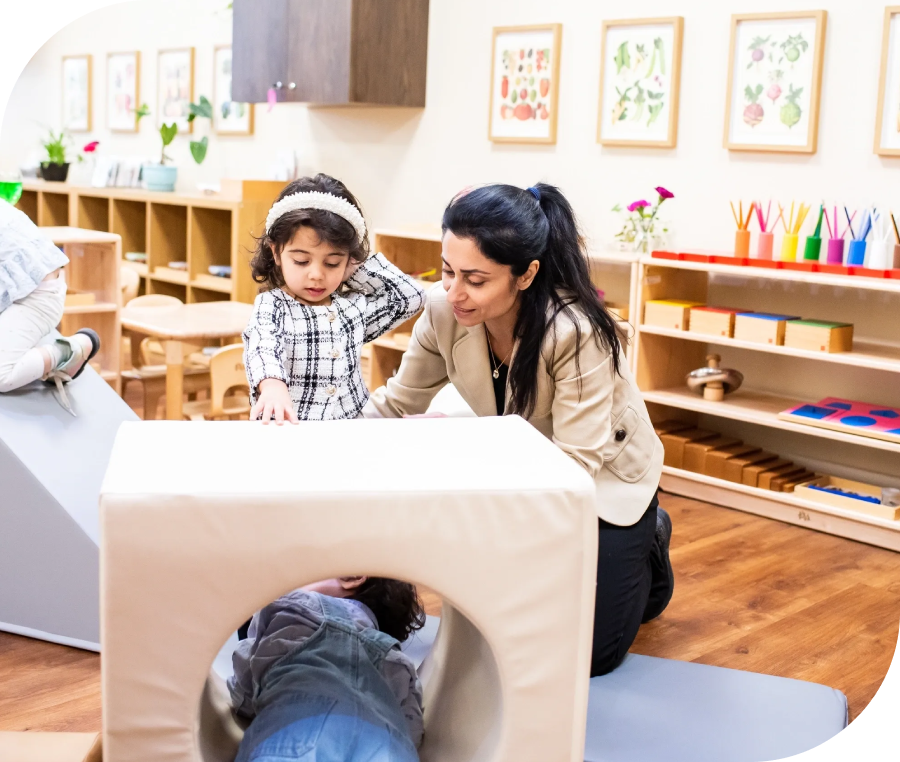 Teacher guiding children in a playroom.
